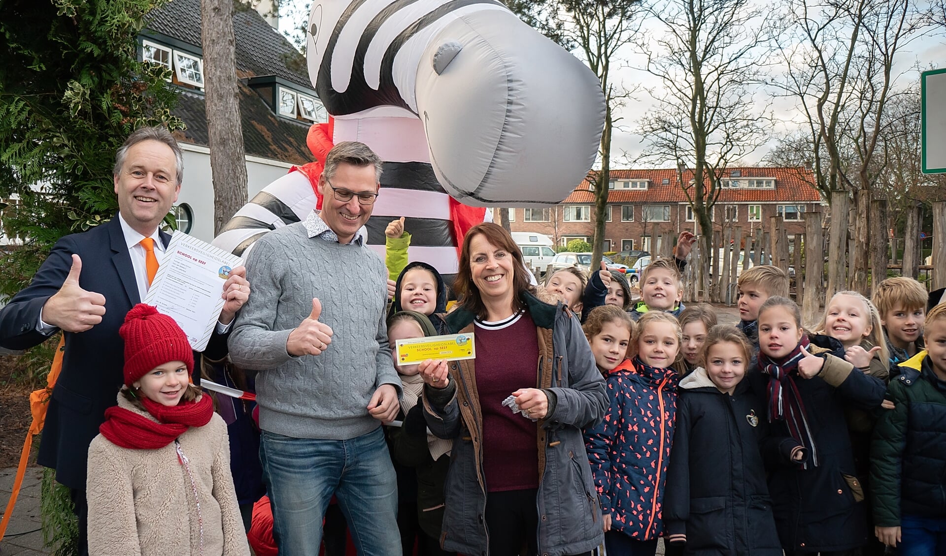 Wethouder Willem Joosten (geheel links) met locatieleider Maarten Meijers en juf Arnica Geertsema en een aantal kinderen van groep 5 bij zebra Seef, de mascotte van School op Seef. | Foto: J.P. Kranenburg 