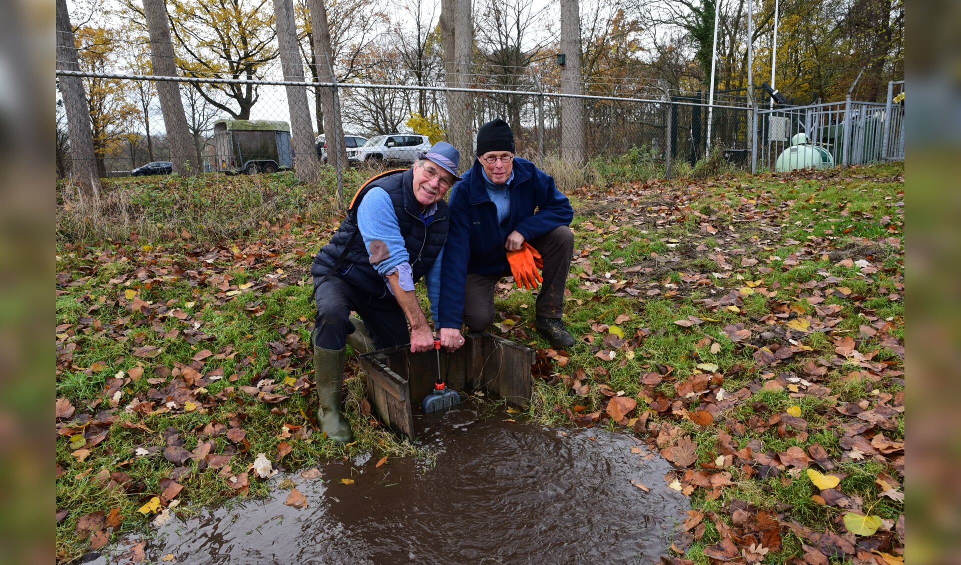 Cees Juffermans en Jan Mulder draaien gezamenlijk de inlaat van de ijsbaan open.