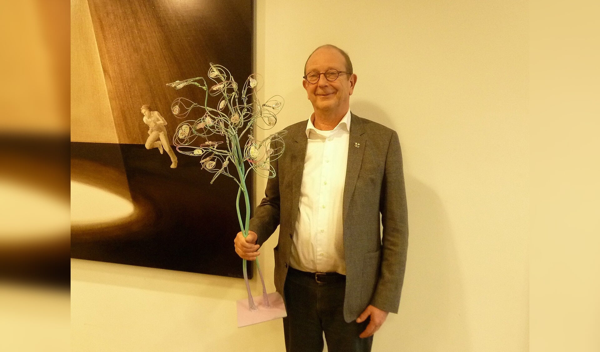 Wethouder Adri de Roon met een verkleinde replica van de kunstboom.