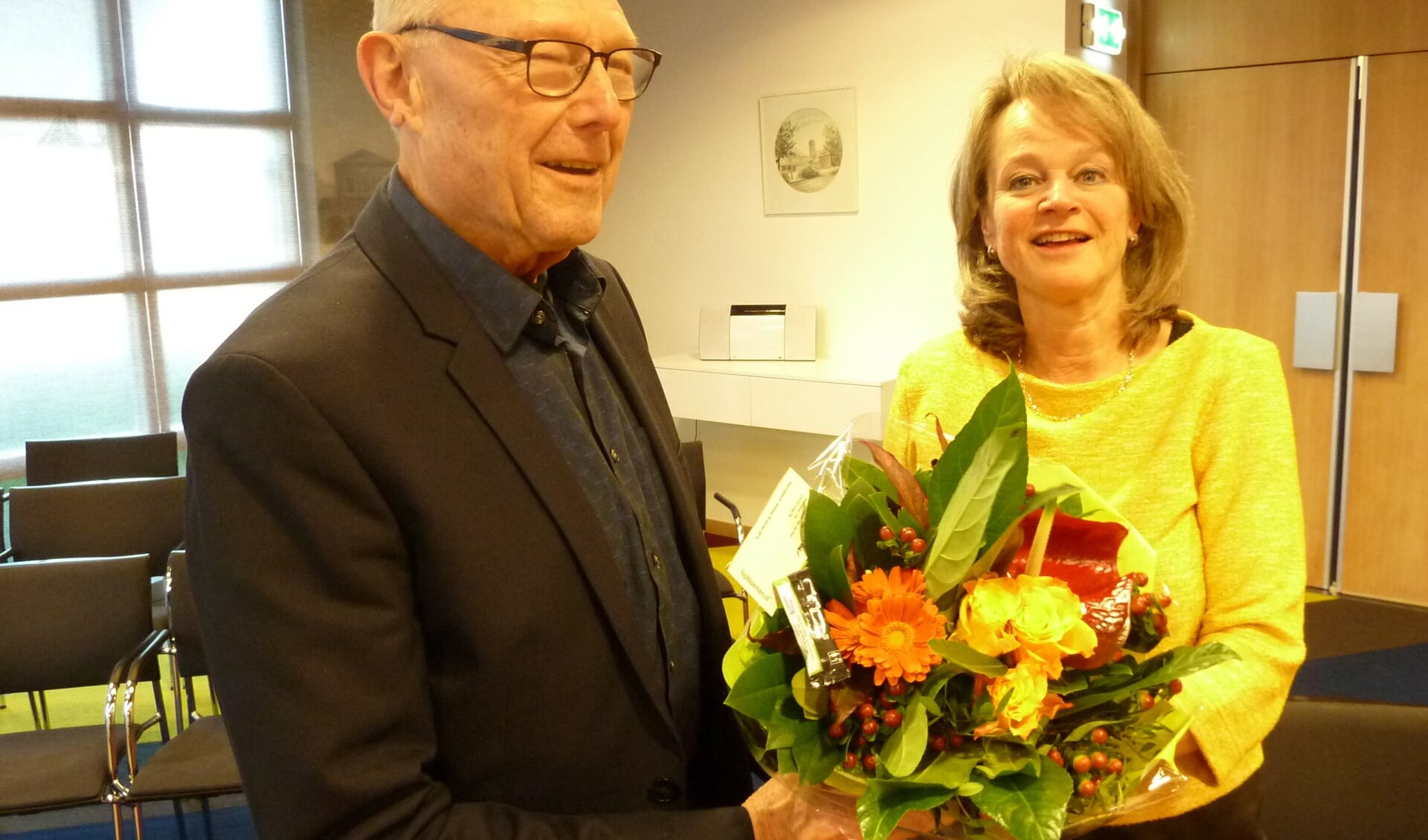 Joop Zwetsloot, de maker van het nieuwe filmpje, krijgt van Lies Spruit een bos bloemen als dank.