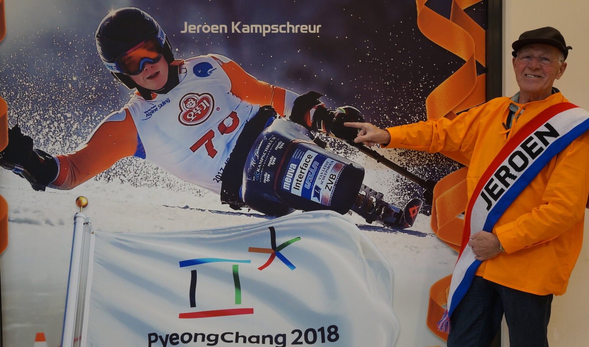 Piet van Leeuwen bij de grote foto van zijn kleinzoon Jeroen Kampschreur die hangt in de etalage van Sport2000 in Winkelhof. 