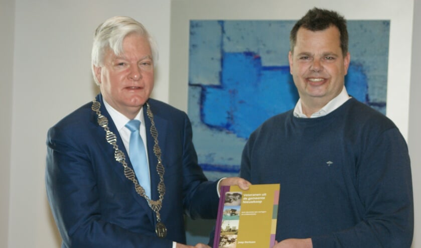 Het eerste exemplaar van het 'Veteranenboek Nieuwkoop' overhandigde Derksen aan burgemeester Buijserd.