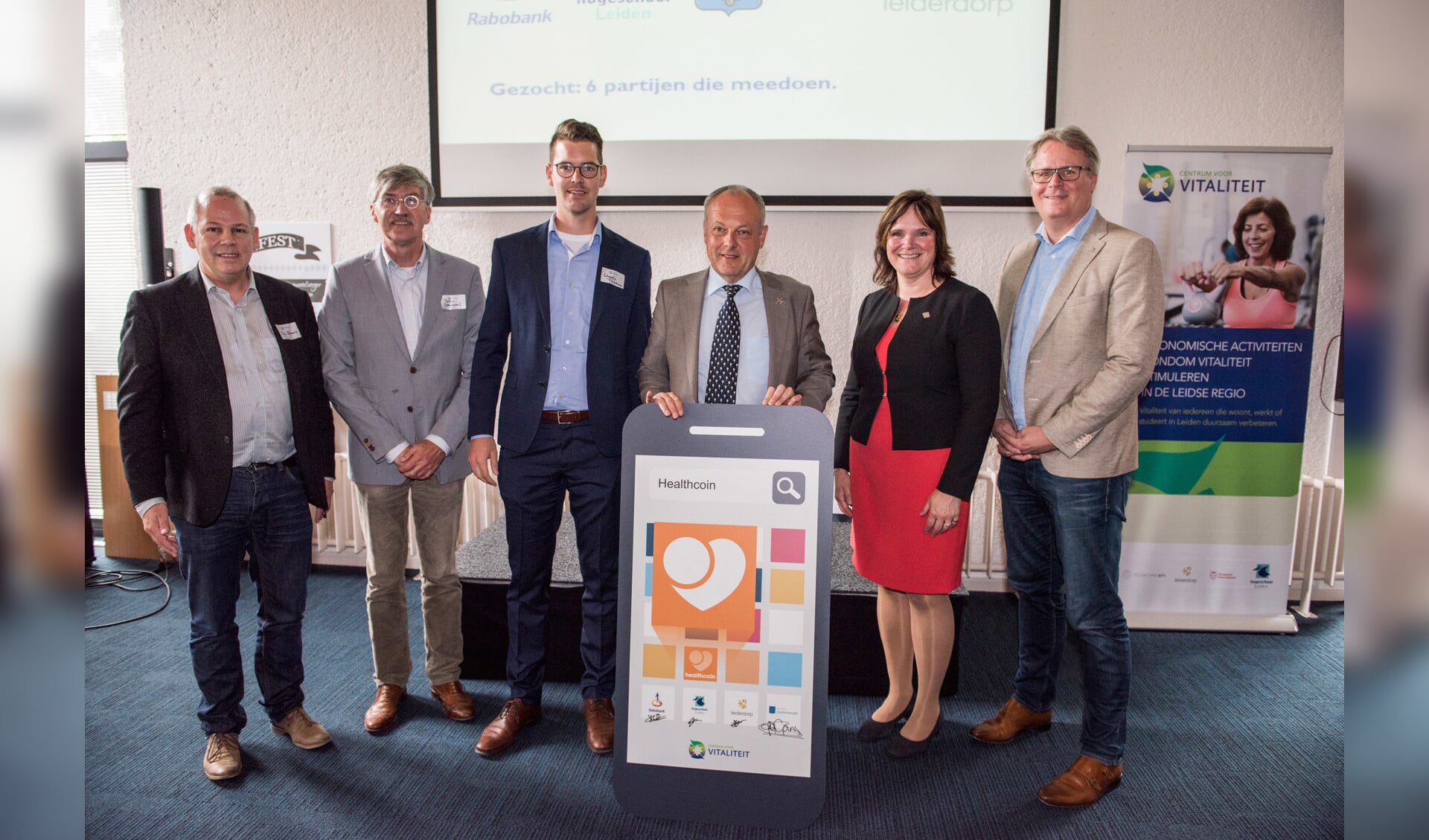 Burgemeester Henri Lenferink van Leiden (3e van rechts) lanceerde de app. Hij wordt geflankeerd door de eerste gebruikers. Onder hen is de gemeente Leiderdorp, hier vertegenwoordigd door wethouder Angelique Beekhuizen. 