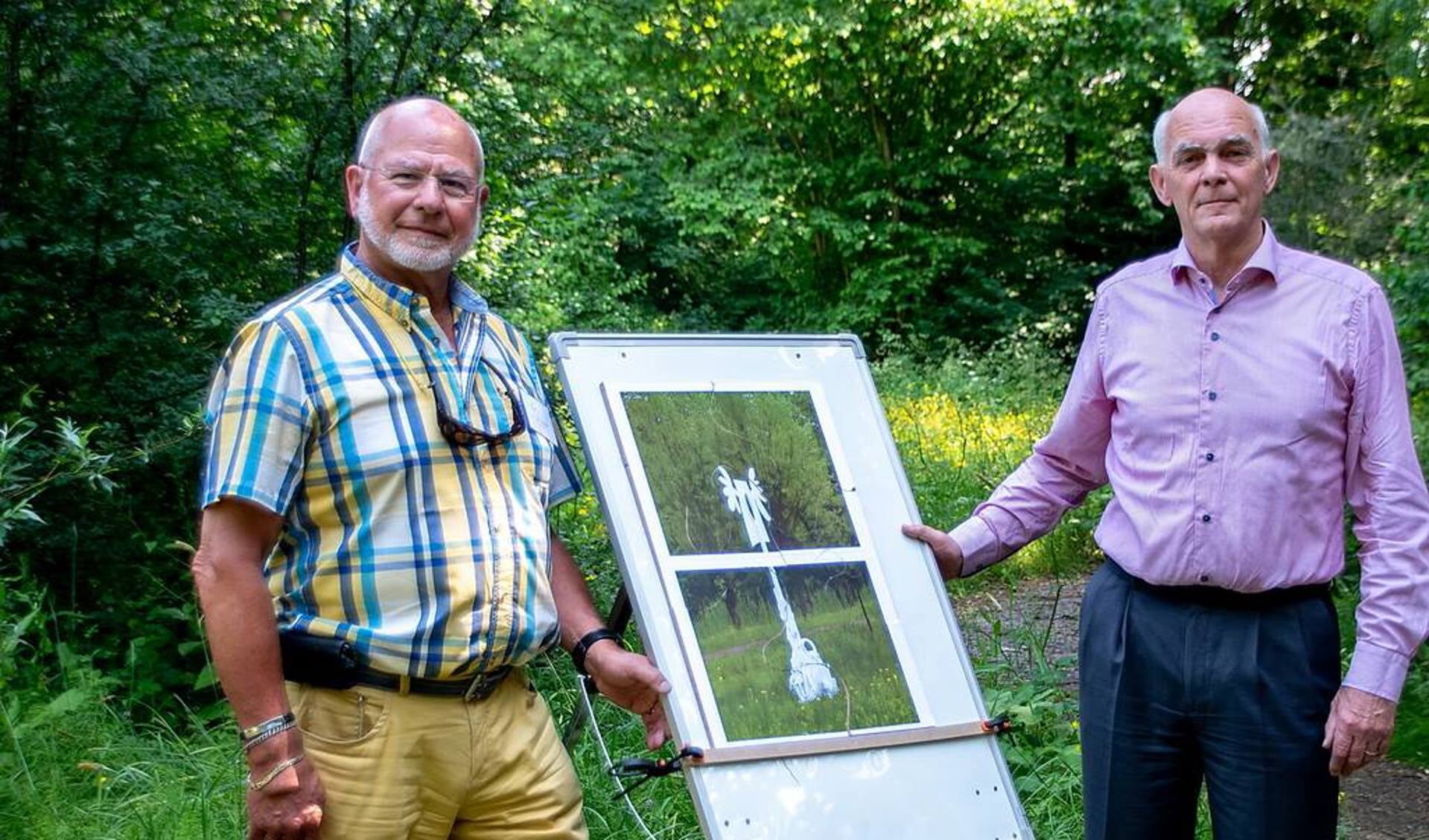 Wethouder Jeff Gardenier (rechts) heeft de puzzel klaar en daarmee de tentoonstelling geopend. Links staat voorzitter Jos Gerrese van de Stichting Kunst in de Heemtuin.