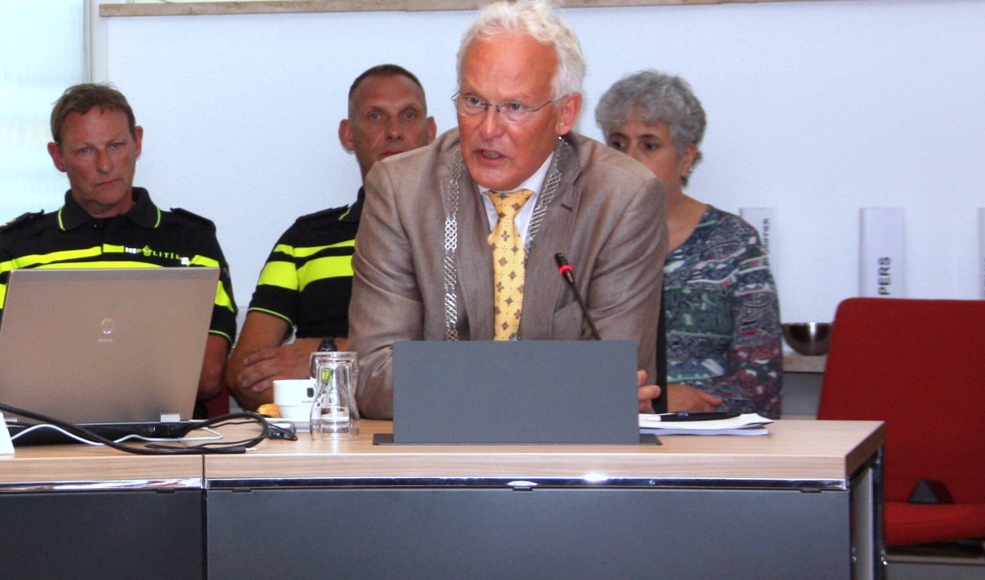 Burgemeester Rijpstra legt in de raadsvergadering  een verklaring af over de noodverordening. Links politiechef Henk Woppenkamp. | Foto: WS