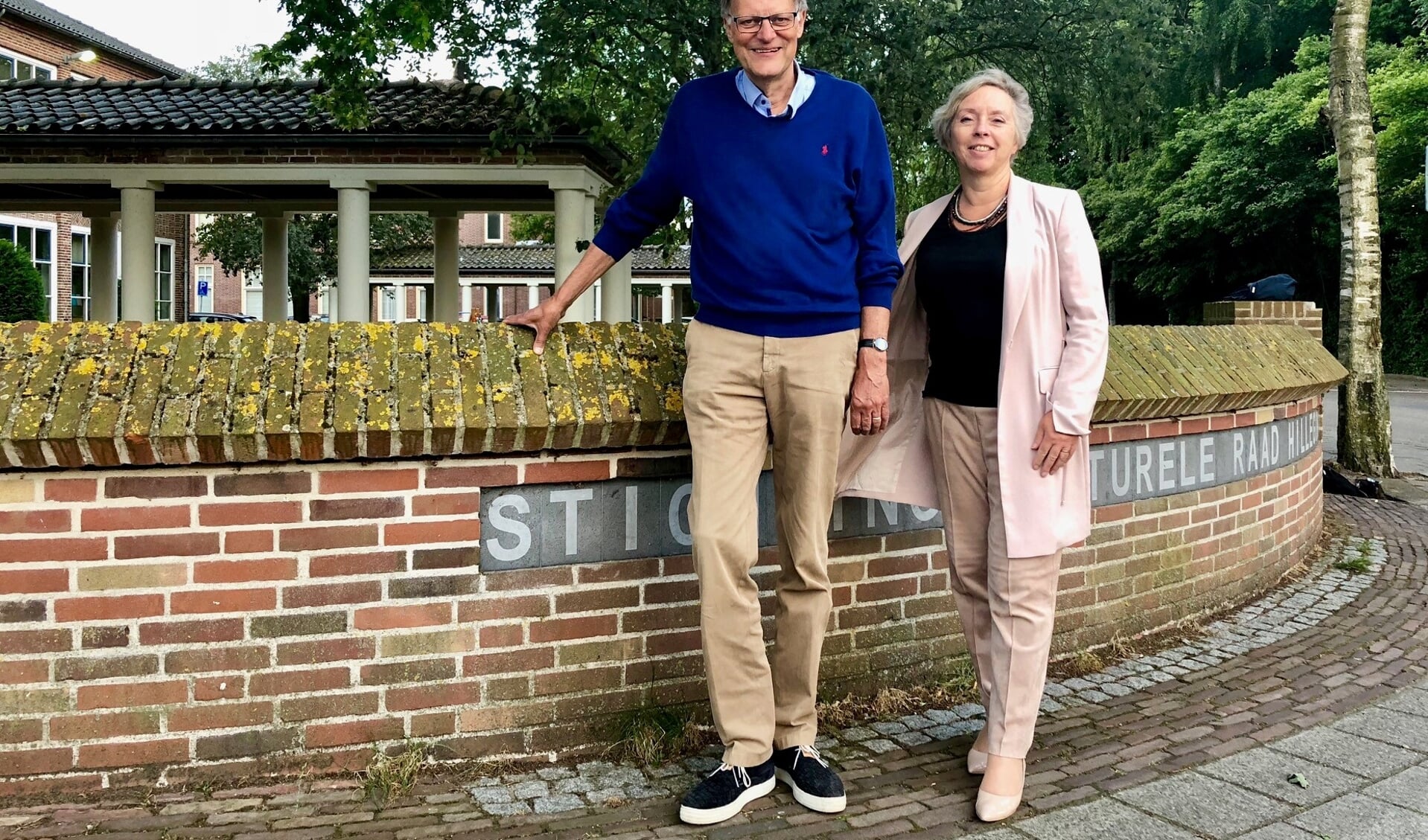Hans Lommerse en Karin Peters bij het bekende muurtje in Hillegom van de Stichting Kulturele Raad op de hoek van de Pr Irenelaan en de Mariastraat. | Foto: Caroline Spaans