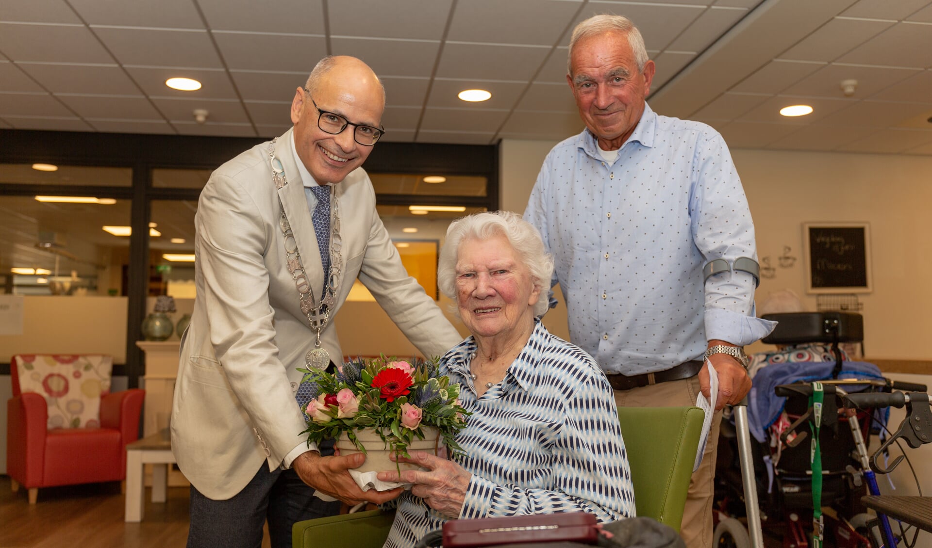 Mevrouw Tuinstra is heel blij met het bloemstukje dat ze kreeg van de burgemeester. | Foto Wil van Elk