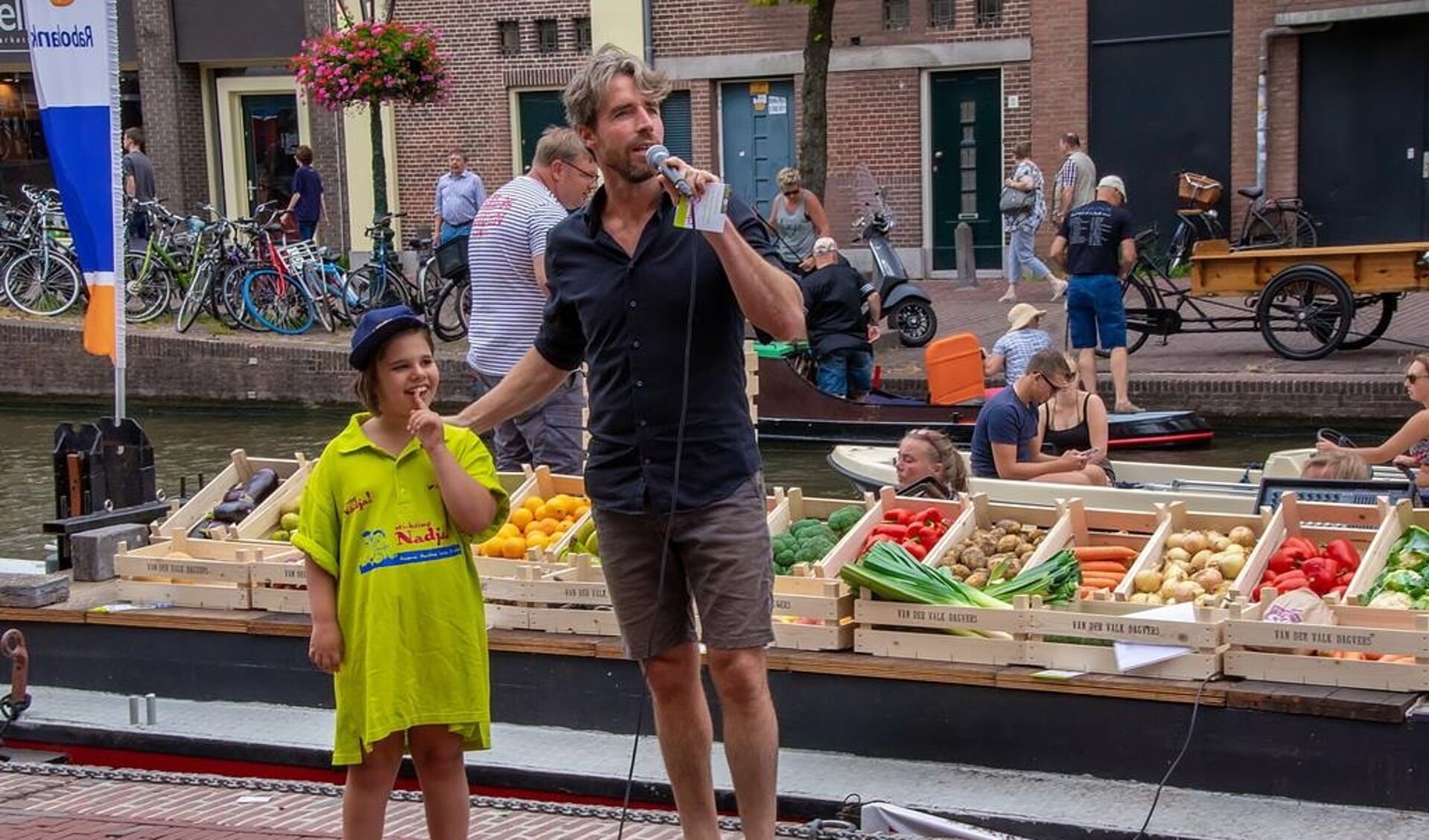 Plastic Soup Surfer Merijn Tinga als veilingmeester, met als hulpje een van de kinderen van Stichting Nadja. 