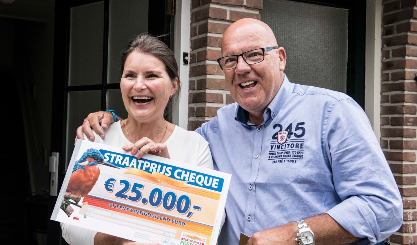 Nicoline uit Oegstgeest wordt verrast door Postcode Loterij-ambassadeur Gaston Starreveld met de PostcodeStraatprijs-cheque. | Foto Jurgen Jacob Lodder 