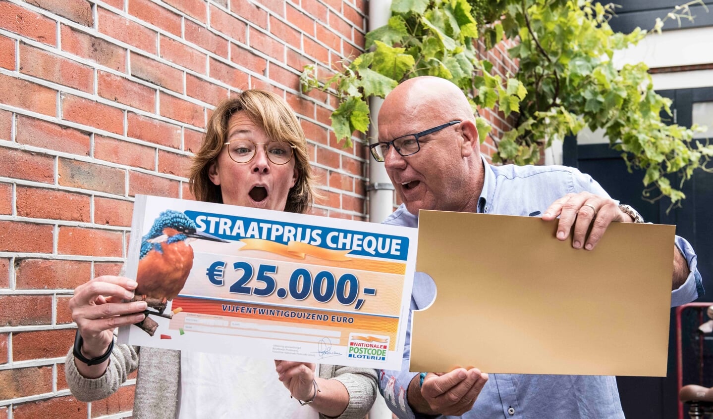Bregje uit Oegstgeest wordt verrast door Postcode Loterij-ambassadeur Gaston Starreveld met de PostcodeStraatprijs-cheque. | Foto Jurgen Jacob Lodder