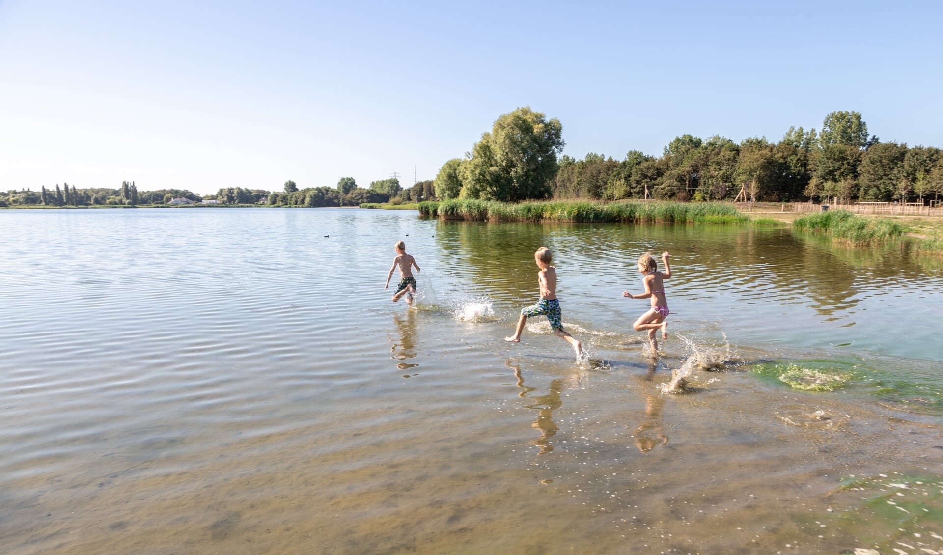 Kinderen rennen maandagochtend een laatste keer het water van de Klinkenbergenplas in. Hun moeder besloot om naar het strand te gaan.