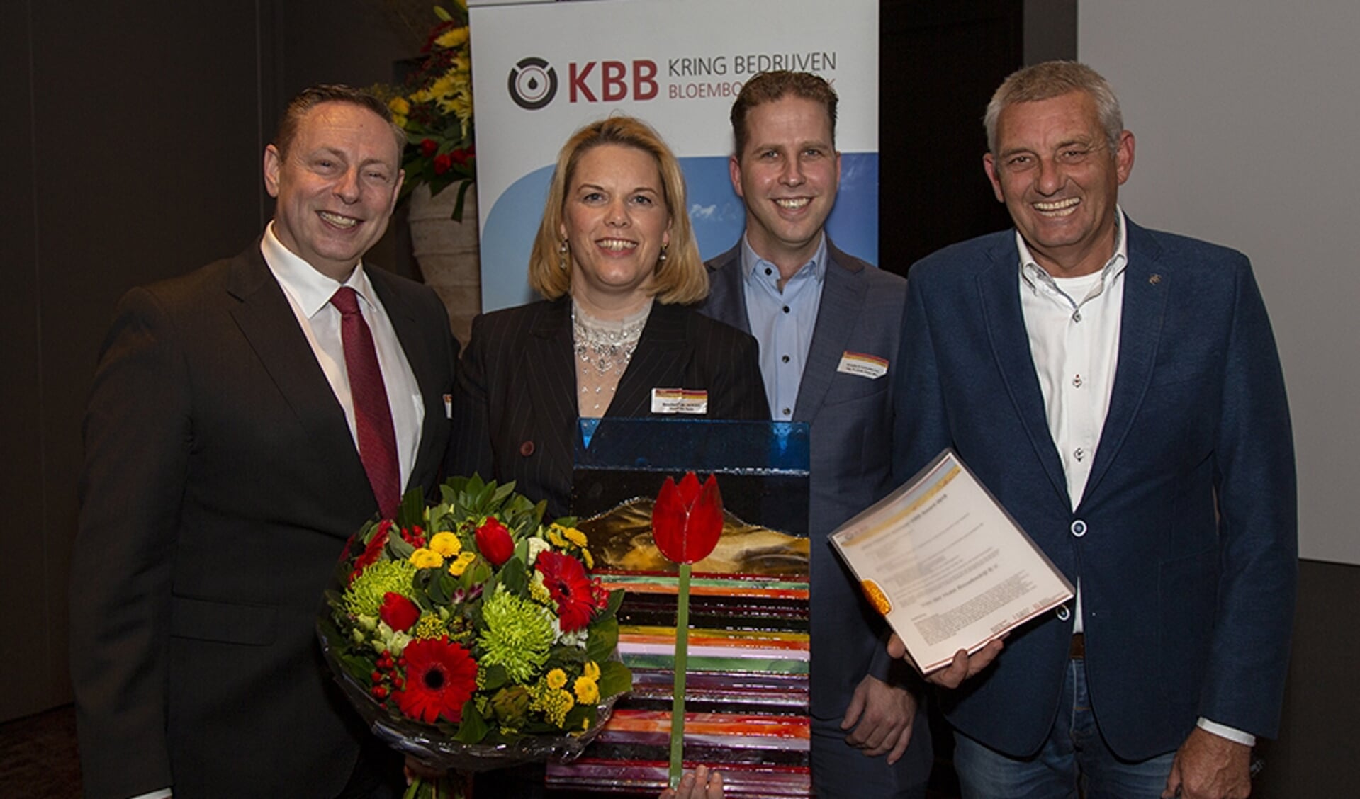 Van der Hulst Bouwbedrijf is de winnaar van de KBB Award 2019. Op de foto (v.l.n.r.)  Arjan Bakker (voorzitter KBB), Yvonne van der Hulst, Rob Pouw (plaatsvervangend voorzitter van de jury KBB Award) en presentator Allard Kalff.