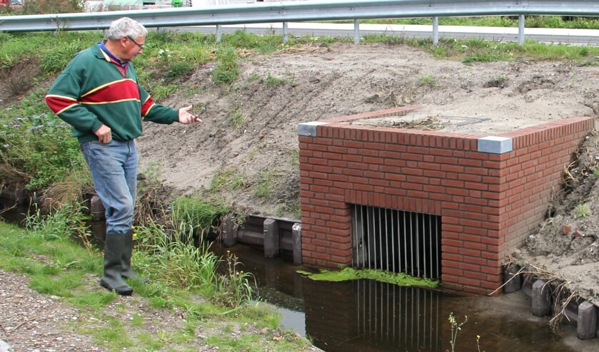 Jan de Ridder wijst de oorzaak van de wateroverlast aan. Deze duiker zou 30 cm. moeten zakken. | Foto: Wim Siemerink