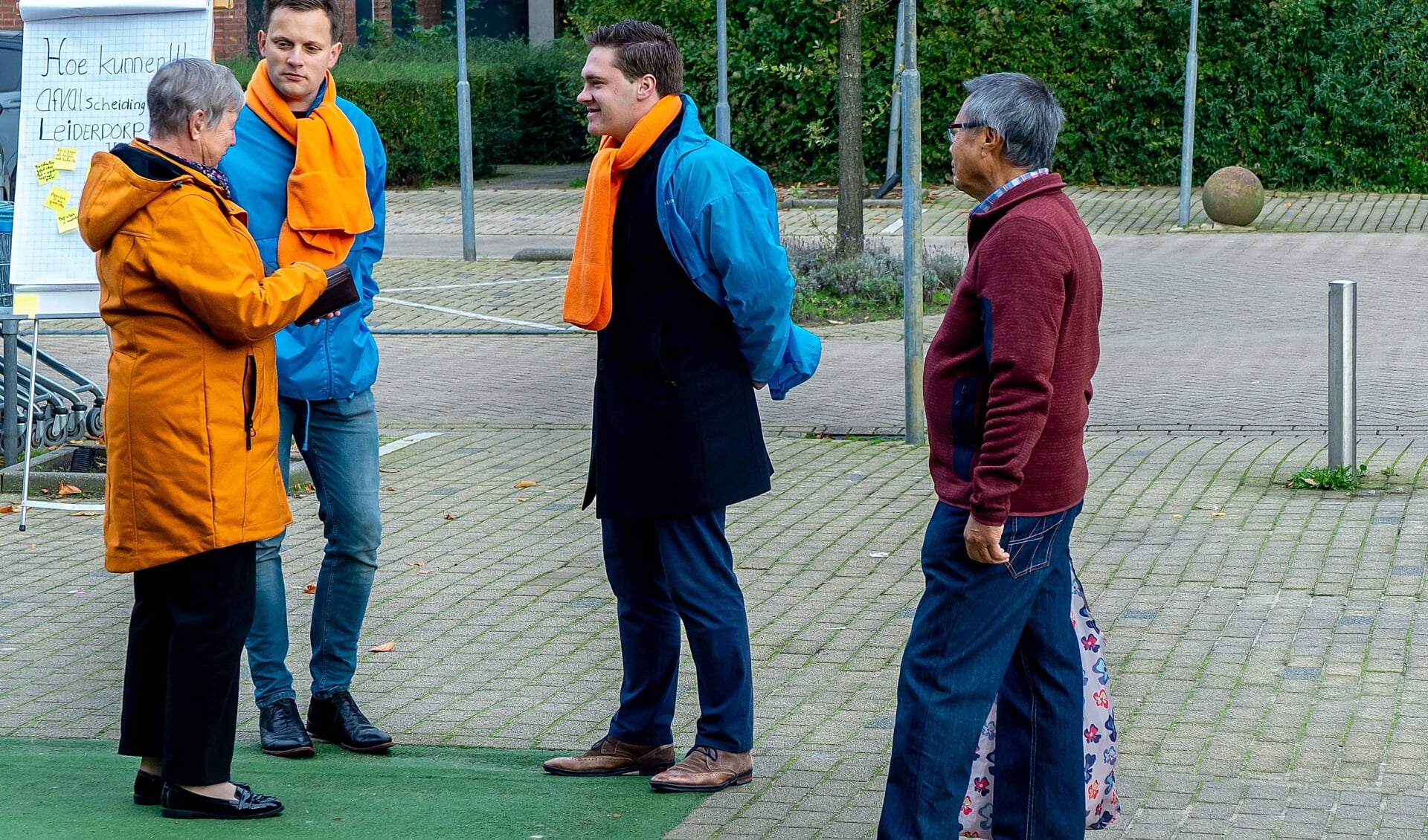 Geert Schipaanboord en Leander Tramper van CU-SGP-fractie (met blauwe jassen) in gesprek met Leiderdorpers. | Foto: J.P. Kranenburg  