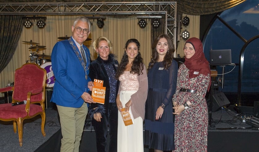 Sjaak van den Berg neemt de dichtbundel in ontvangst van Ina Roestenburg (taalmaatje), Marina, Yuliya en Eman. | Foto: Willem Krol