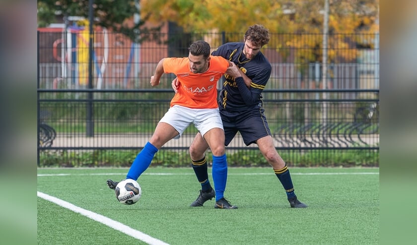Ruben Groeneveld, verdediger van FC Oegstgeest, heeft zijn handen vol aan SV Nieuwkoop.