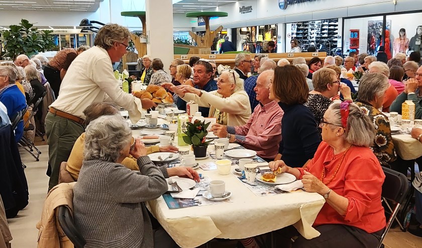 Marten Brederode deelt broodjes uit aan een van de lange tafels.