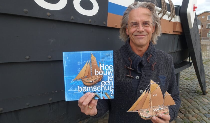 Bert van der Meij met zijn boek bij de KW88 aan de Boulevard.