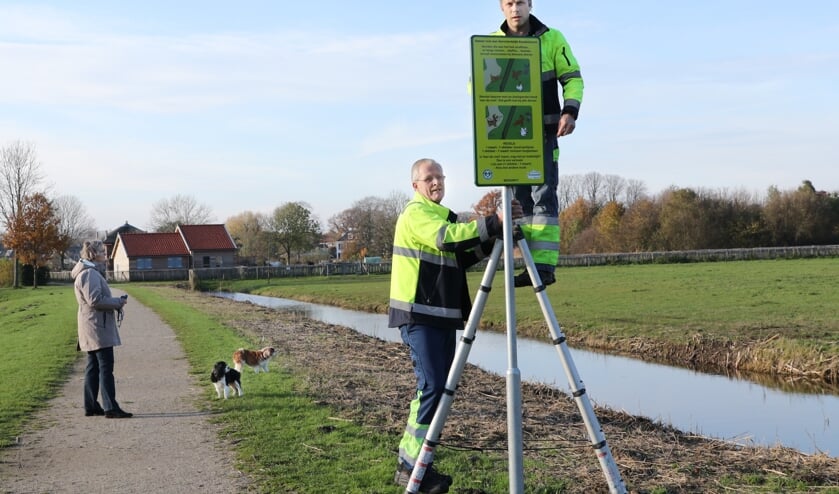 Gemeentemedewerkers Aad Heemskerk (l) en Bas de Zwart plaatsen de borden op Koudenhoorn.| Foto: Novus Image - Esther Moonen