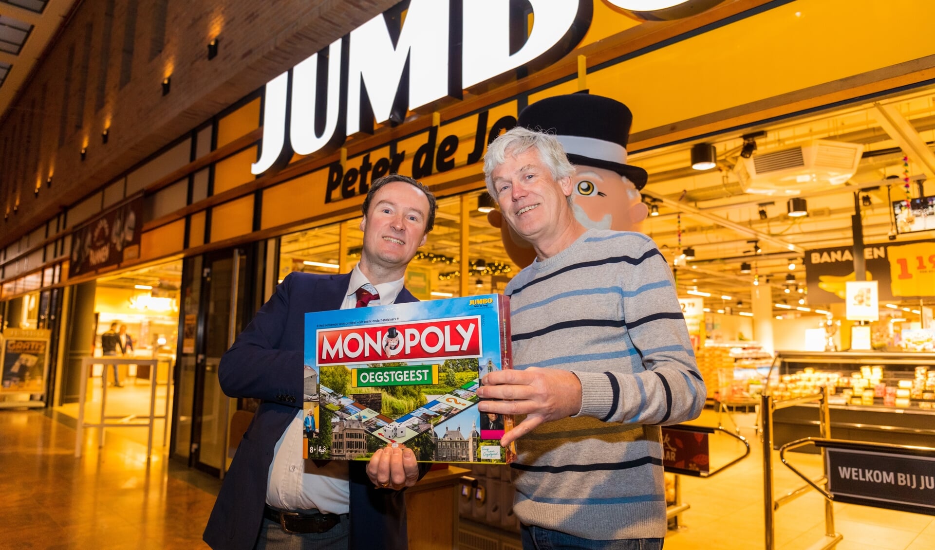 Jumbo-bedrijfsleider Rien de Haas overhandigt het spel, in aanwezigheid van Mr. Monopoly, aan Wil van Elk. | Foto Willemien Timmers