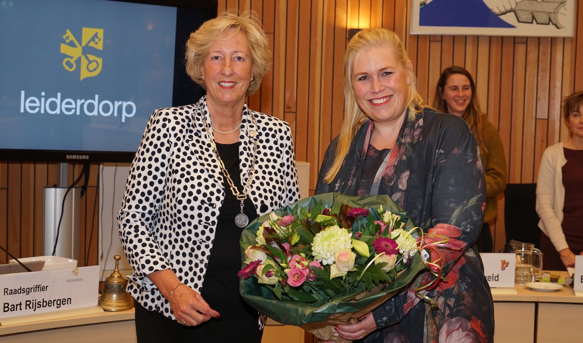 De kersverse wethouder Martine de Bas (rechts) krijgt bloemen van burgemeester Laila Driessen. | Foto: C. v.d. Laan
