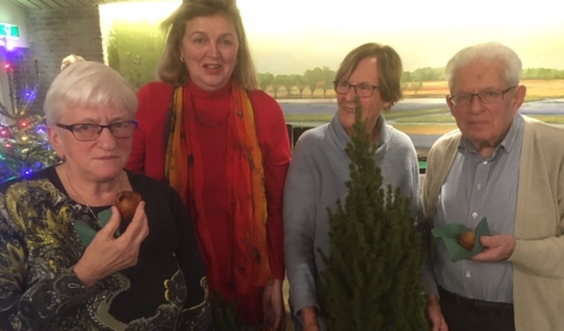 De winnaars Anita van de Aardwegh en André van der Meeren (met oliebol, uiterst links en uiterst rechts) en in het midden Anja Spierings en Marianne Freke van de organisatie die de prijzen uitreikten. 