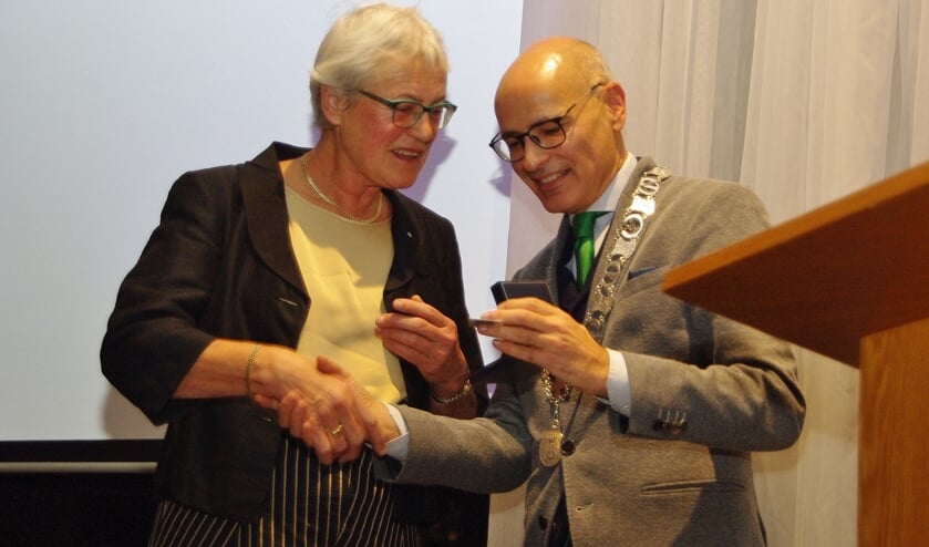 Burgemeester Emile Jaensch overhandigt Rianne Meester de erepenning.