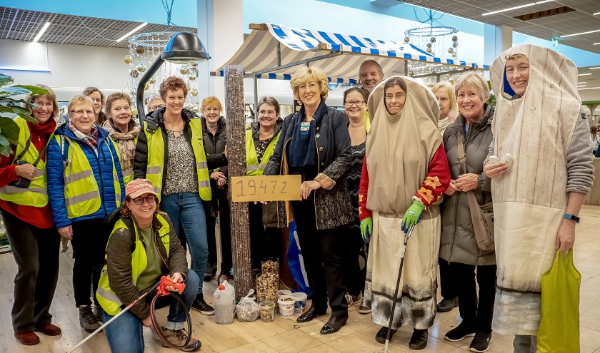 Burgemeester Laila Driessen, hier omringd door Straatjutters, toont de oogst van een dagje peuken rapen in Leiderdorp.