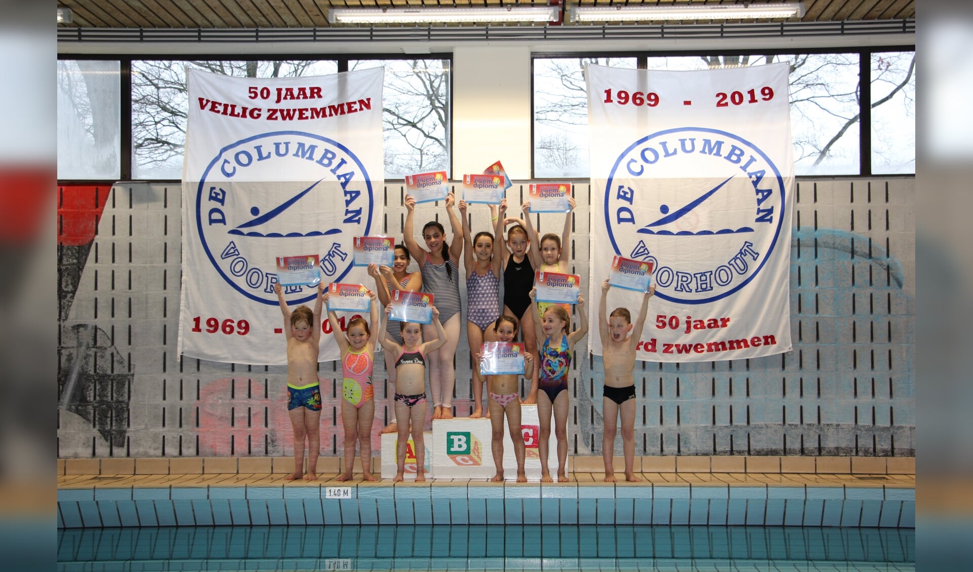 Elf afzwemmers tonen trots hun zwemdiploma A. 
