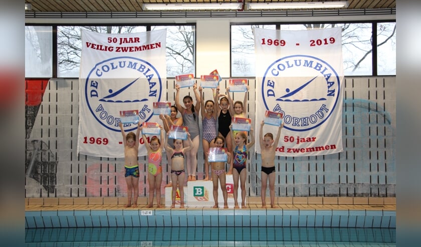 Elf afzwemmers tonen trots hun zwemdiploma A.   