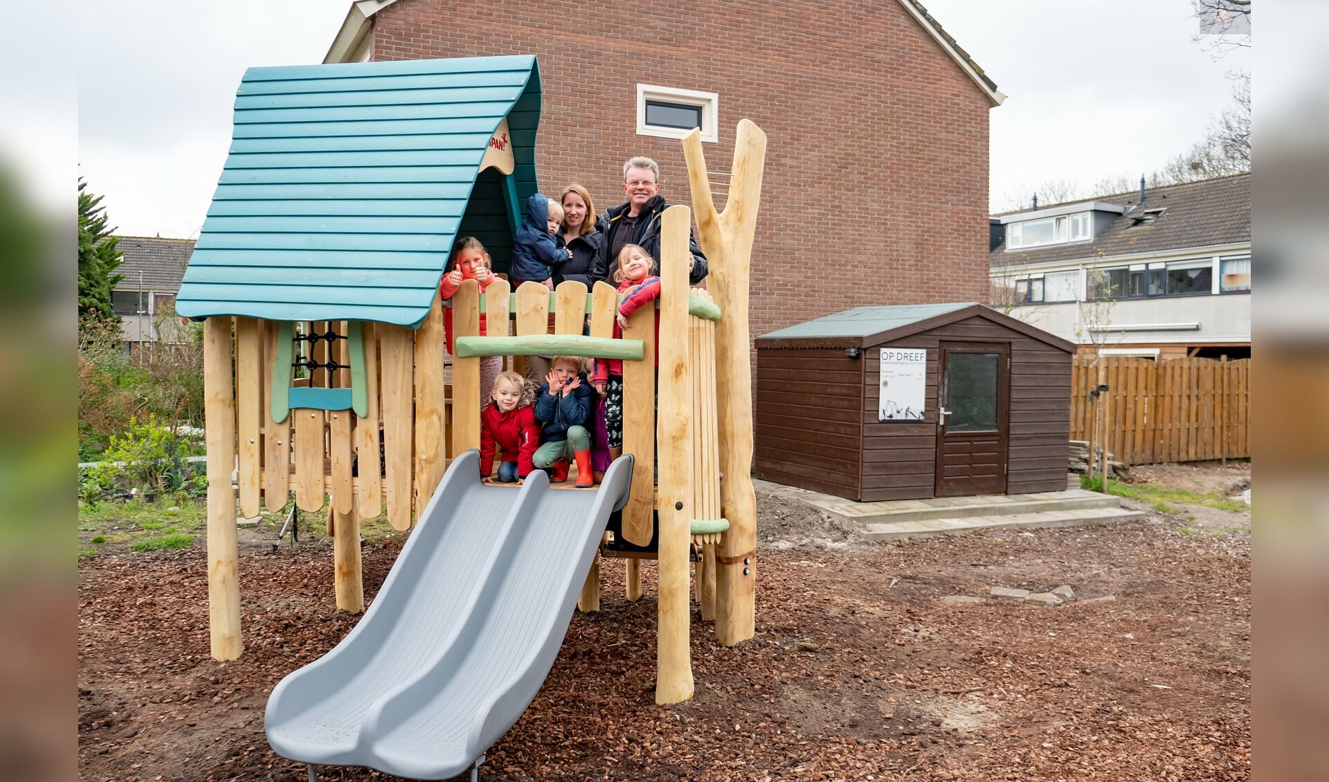 Bestuursleden Jeanine van Jaarsveld en Albert Verkuyl van buurtverenigingen Op Dreef met een aantal buurtkinderen op het nieuwe speelhuisje. | Foto: J.P. Kranenburg   