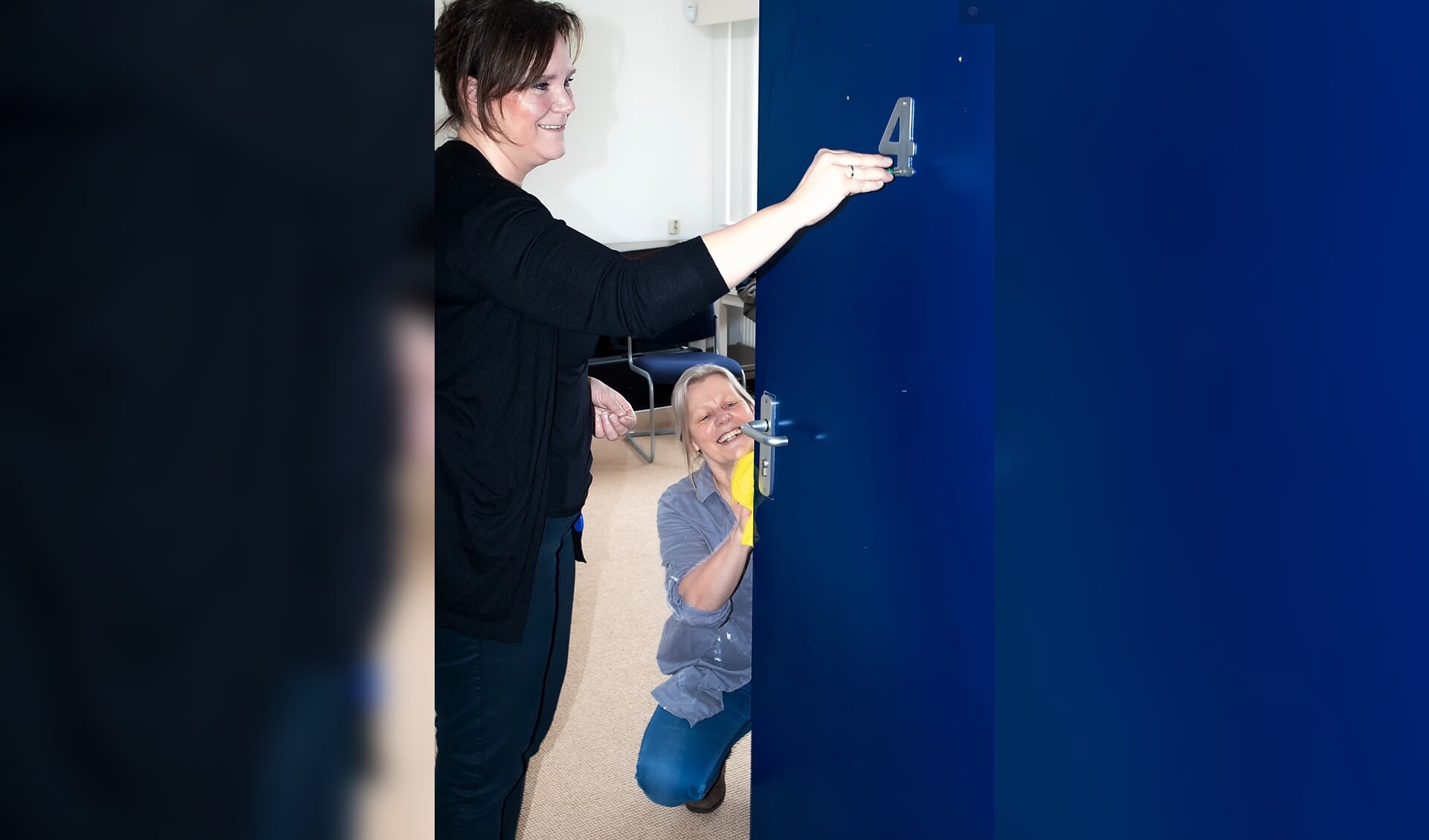 Wethouder Angelique Beekhuizen schroeft het kamernummer van een deur die ondertussen schoongemaakt wordt door Bernadette Pollen van Stichting MOL.