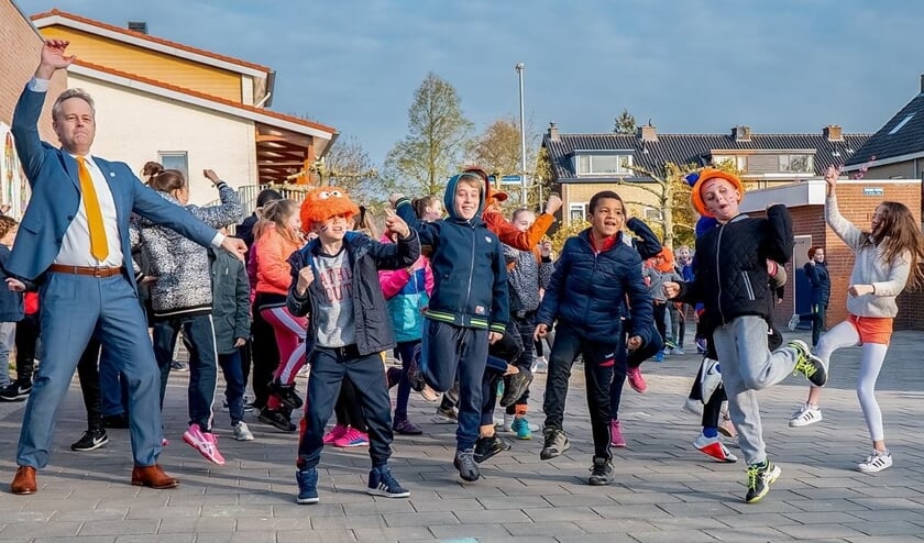 Op KBS De Schakel werden de Koningsspelen geopend met het dansen en zingen van de Pasapas. Ook wethouder Willem Joosten van onderwijs en sport (geheel links) deed mee.