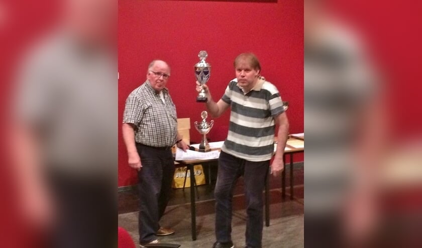 Internationale schaakmeester Fred Slingerland neemt uit handen van wedstrijdleider Cok Ippel de beker in ontvangst.