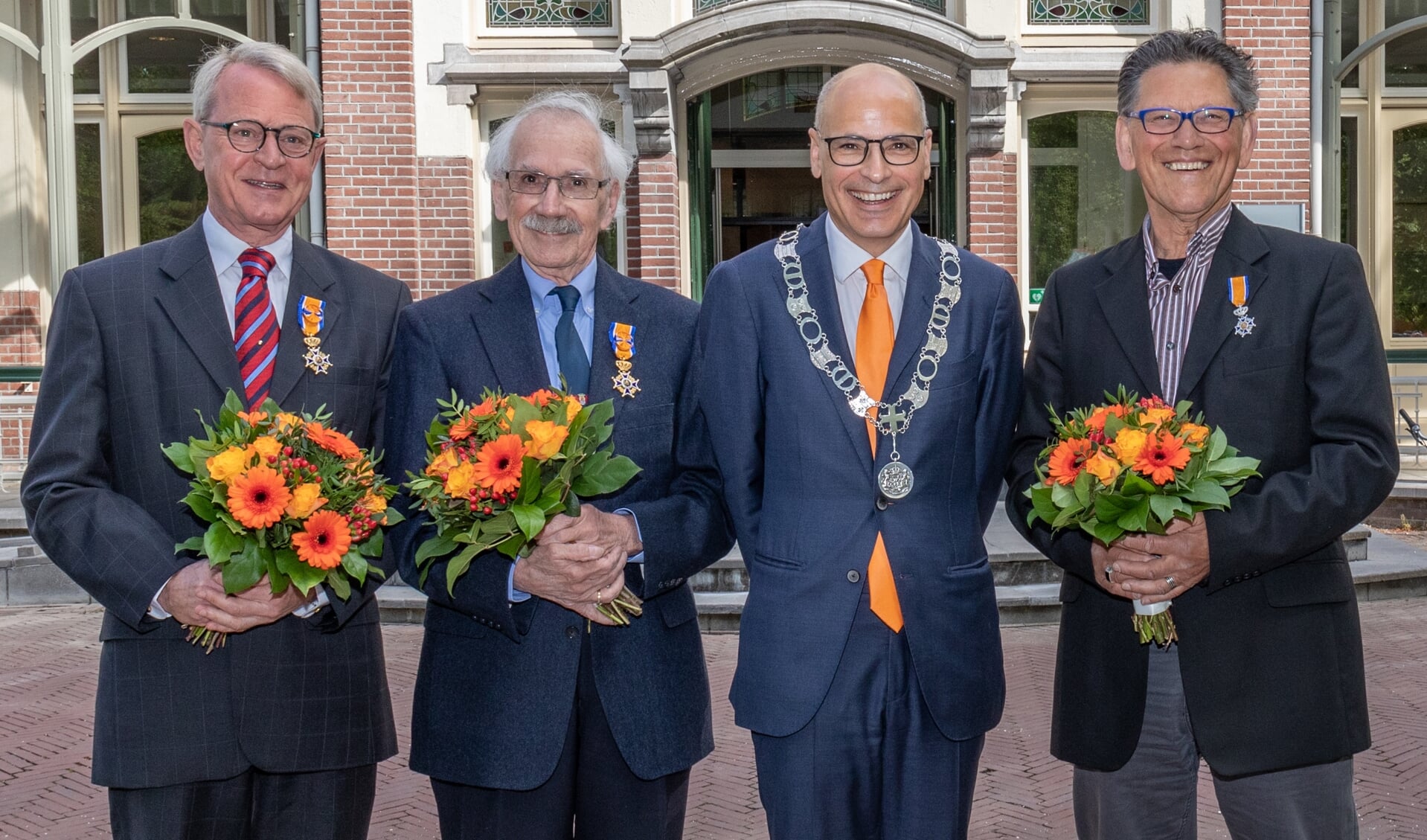 Gedecoreerden Ernst Koningsveld, Rob Demaree en Louis Weyzig met burgemeester Emile Jaensch voor het Oegstgeester gemeentehuis. 