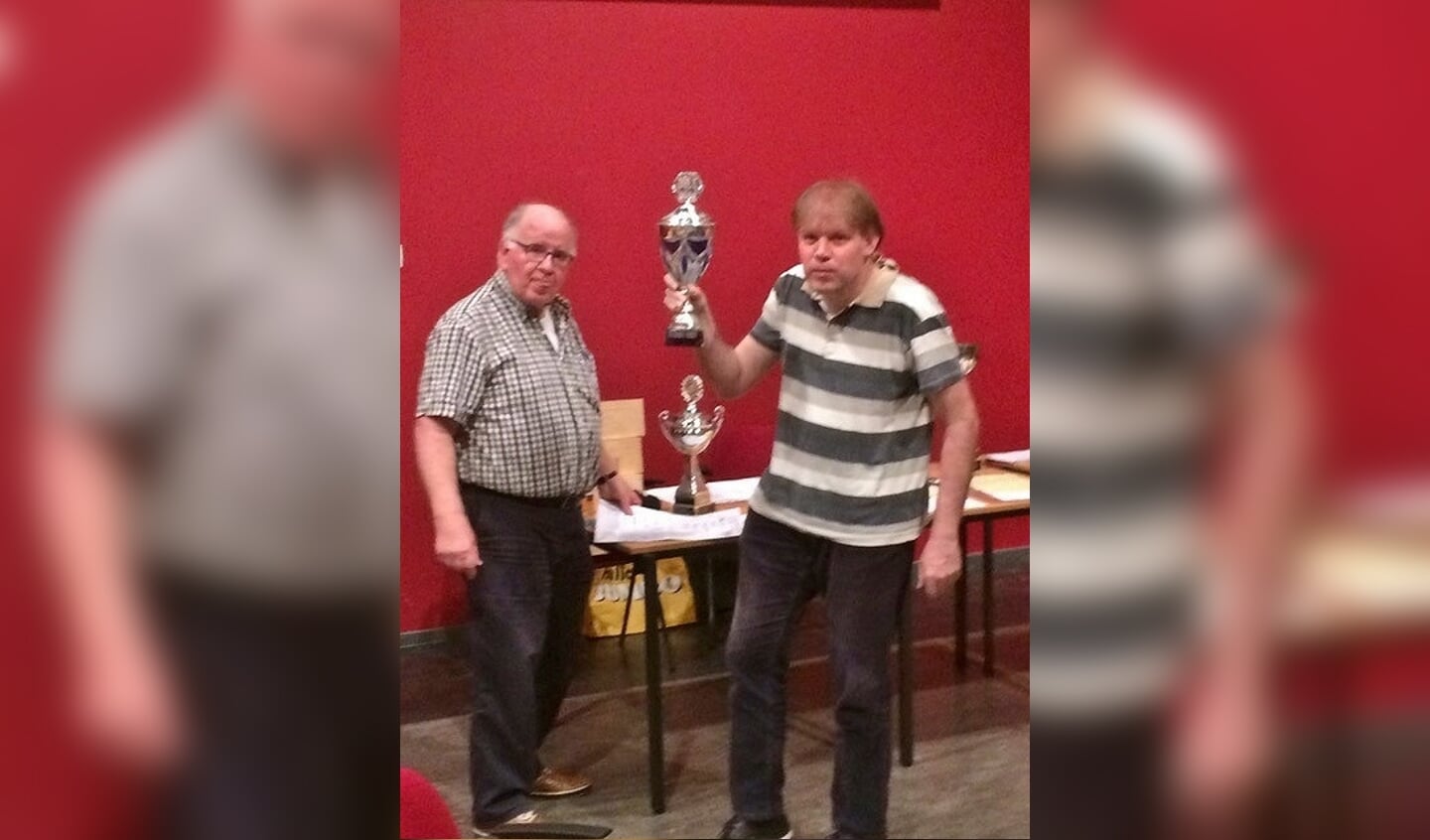 Internationale schaakmeester Fred Slingerland neemt uit handen van wedstrijdleider Cok Ippel de beker in ontvangst.