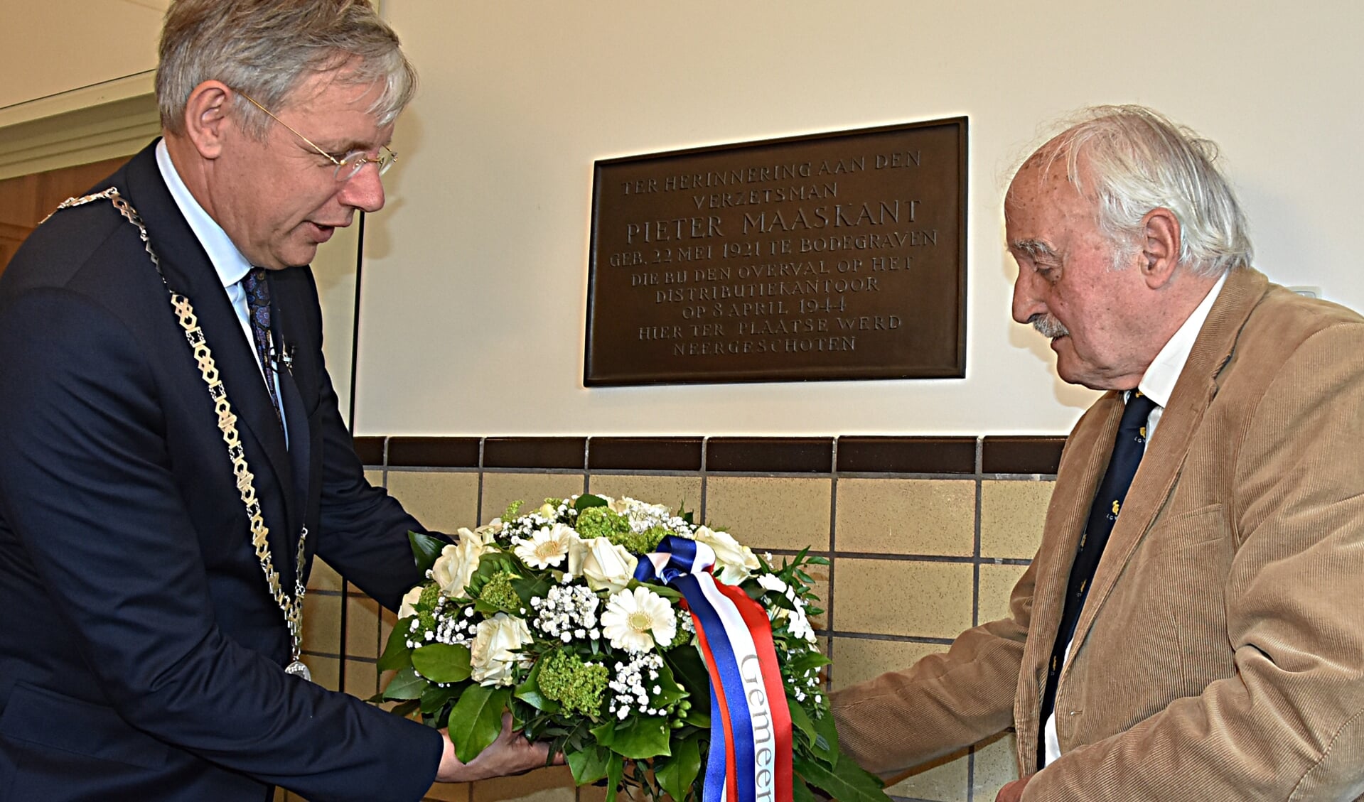 Neef Pieter Maaskant legt samen met burgemeester Cornelis Visser een bloemstuk bij de plaquette. | Foto en tekst: Piet van Kampen