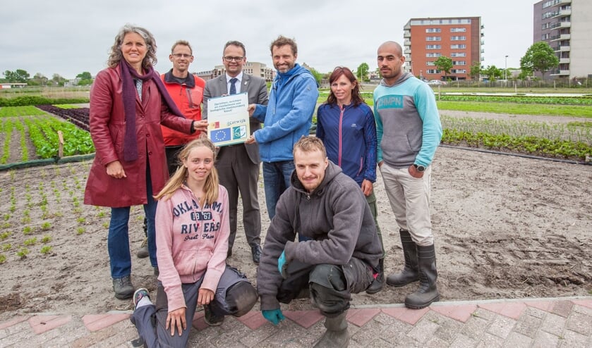 Sebastiaan Bos ontvangt een plaquette om de eerste oogst in de Zanderij te markeren. | Foto: Adrie van Duijvenvoorde