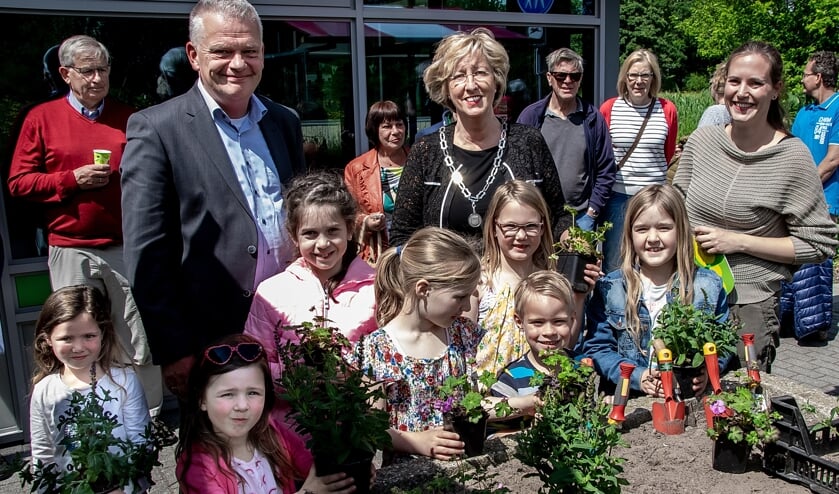 Wethouder Daan Binnendijk, burgemeester Laila Driessen en MEC medewerkster Marieke Weishaupt met een aantal jonge natuurliefhebbers bij de  plantenbak, waarin vlak voor de opening de laatste plantjes gezet werden.   