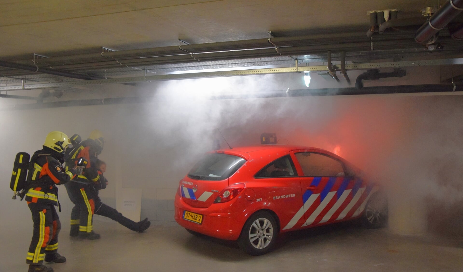 De brandweer redt een 'slachtoffer' bij de brandweeroefening in de parkeergarage van De Ommedijk. 