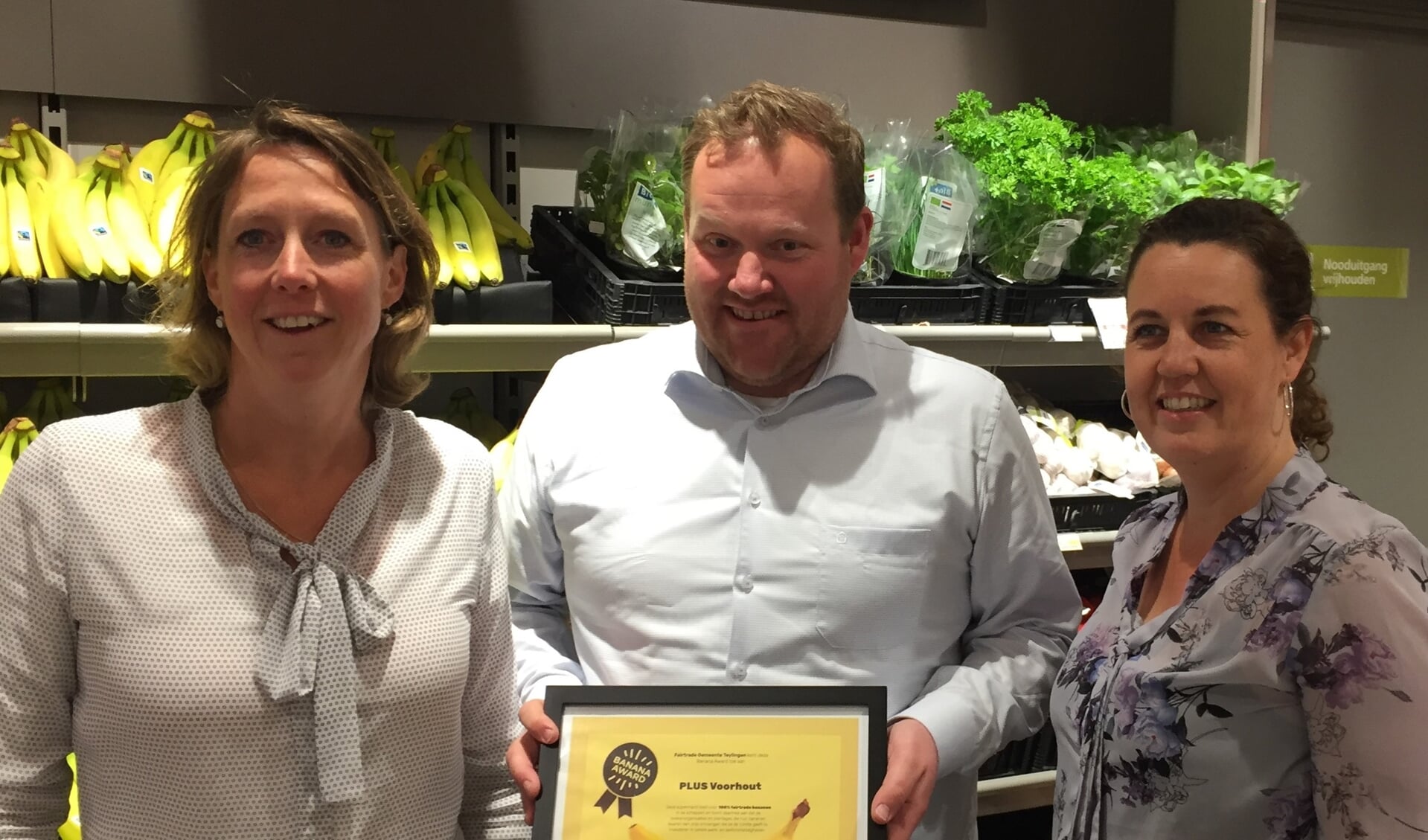 Miranda van Leeuwen en Wendela Seyger van Ladies’ Circle Voorhout, ambassadeur van Teylingen Fairtrade Gemeente, overhandigen de Banana Award aan eigenaar Joop van Dijk. | Foto: pr.