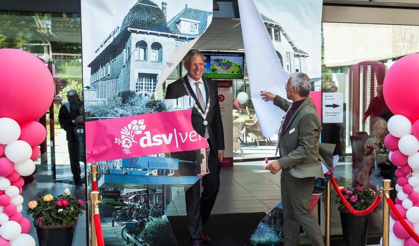 Burgemeester Cornelis Visser loopt door een afbeelden van het oude Gast- en Weeshuis, een voorganger van de Duinrand.