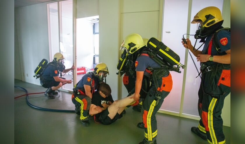 De brandweer brengt een slachtoffer van de rook in veiligheid.