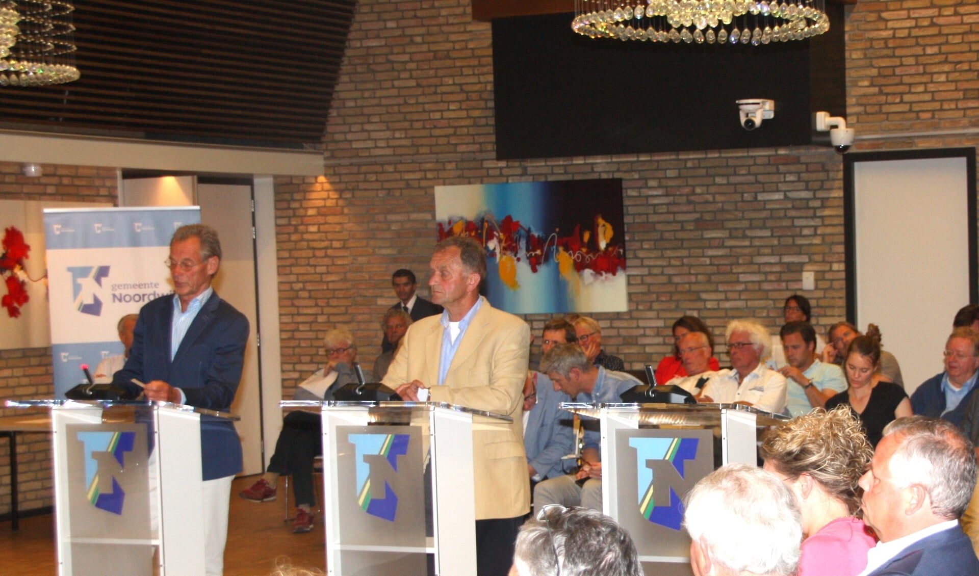 De CDA-raadsleden Beugelsdijk en van Haaster achter de interruptiemicrofoon bij de discussie over GOM-woningen.