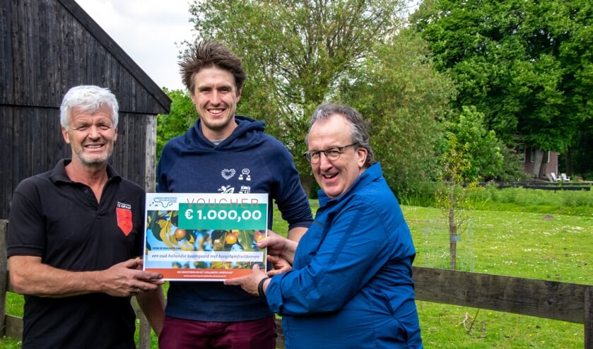 Peter van den Akker overhandigt de cheque van het Landschapsfond aan vader en zoon De Graaf.