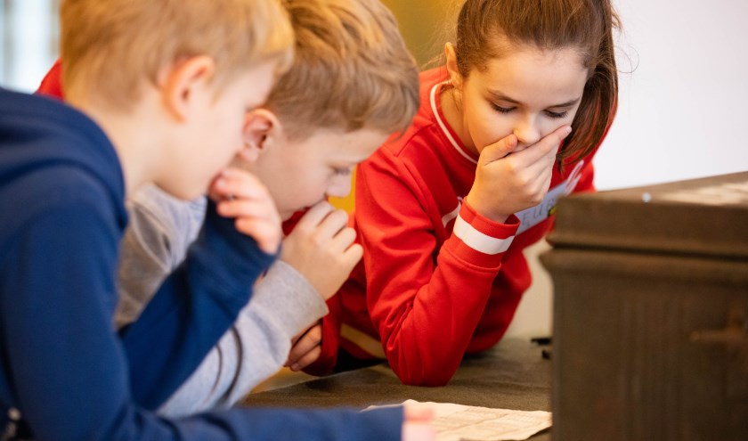 Kinderen spelen de omgekeerde escape room in de bibliotheek. | Foto: pr.
