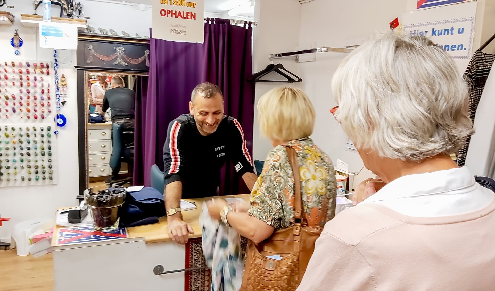 Umit Arslan helpt klanten in zijn naaiatelier De Witte Schaar in winkelcentrum Winkelhof.