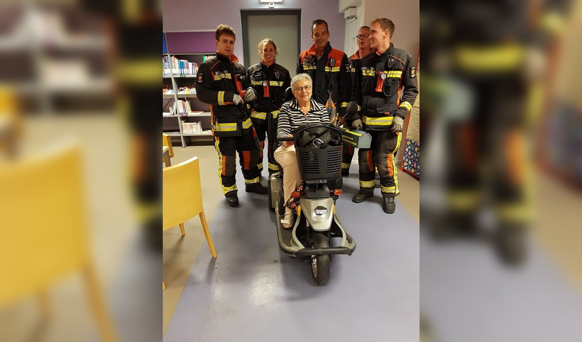 Egberdien Keesenberg met de brandweerploeg die haar scootmobiel uit de lift wist te krijgen. 