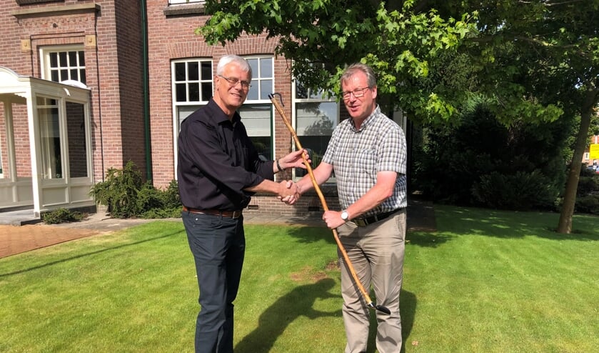 Het stokje, in de vorm van de herdersstaf, wordt doorgegeven aan pastoor Martien Straathof. | Foto: Caroline Spaans.
