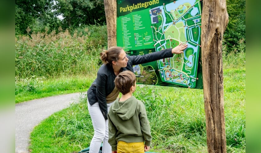 Marieke Weishaupt van het Milieu Educatief Centrum bekijkt het nieuwe informatiebord samen met Sebastiaan Bakx die wethouder Binnendijk een handje hielp met de onthulling.